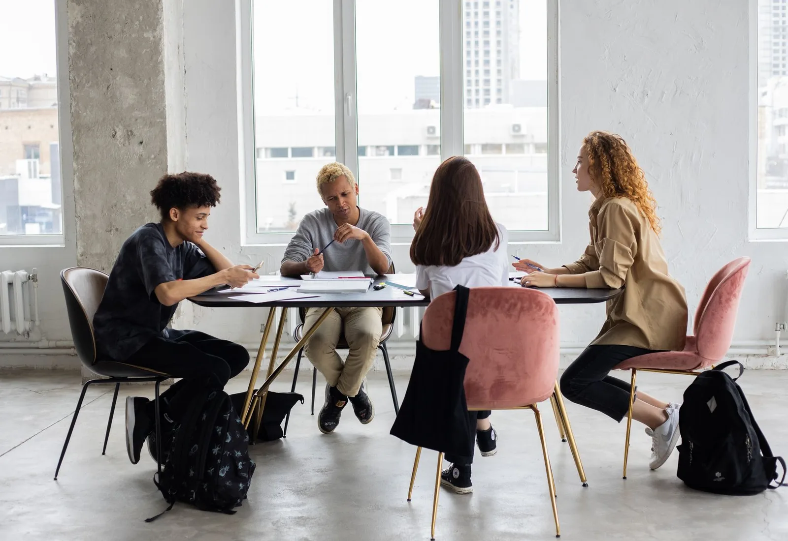A diverse group of young adults collaborating around a table during a study project