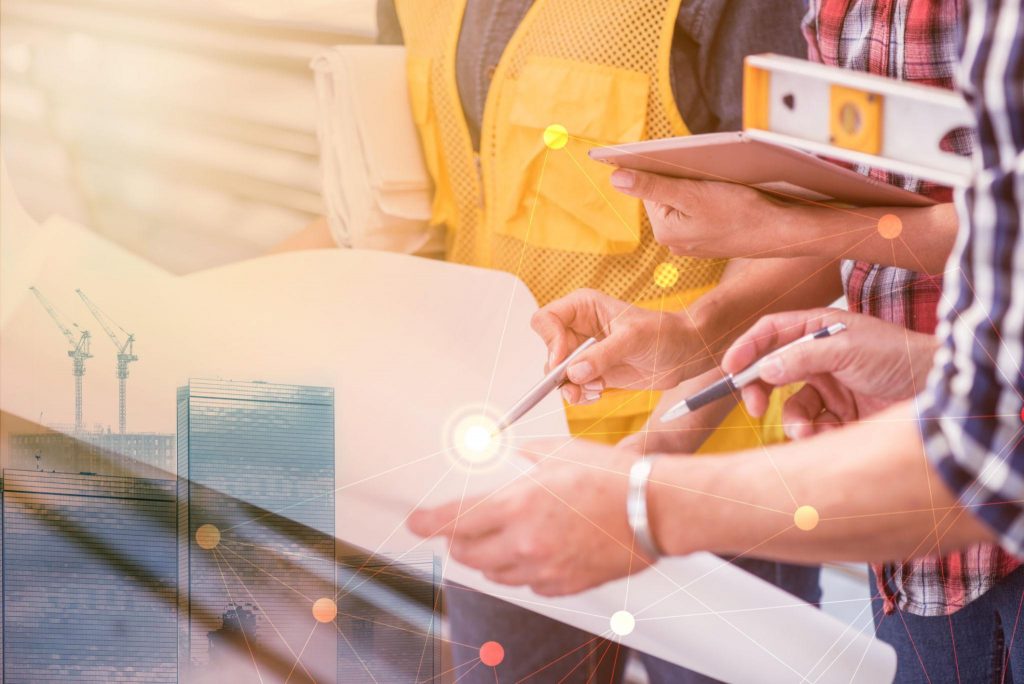 Professionals collaborating on a construction project using digital tools, combining planning, coordination, and real-world application.