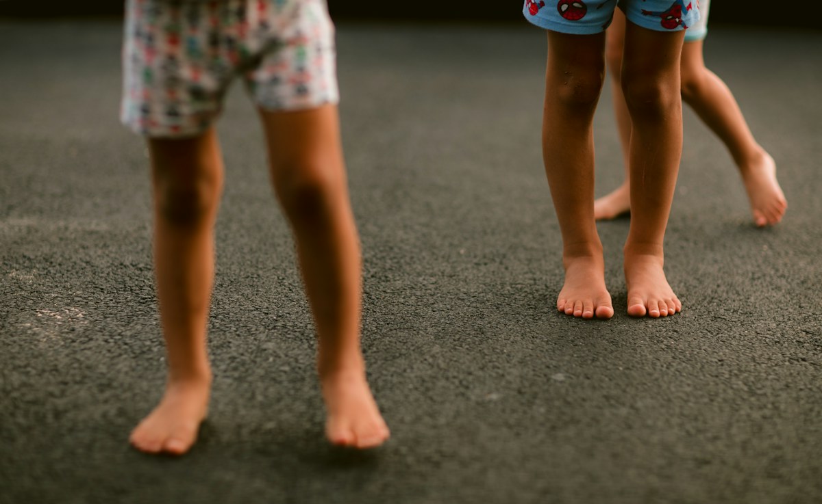 Child standing on a paved outdoor play area