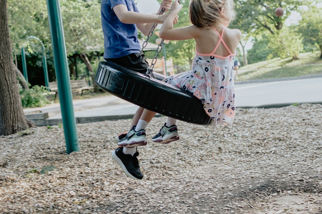 Children playing together on a tyre swing at an outdoor playground