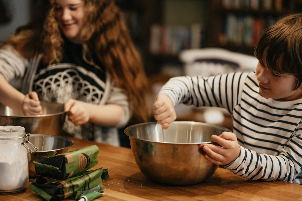 Children working together on a baking activity at a kitchen table