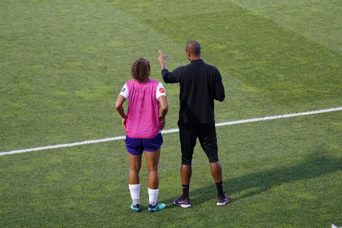 Sports coach speaking with a group before a game